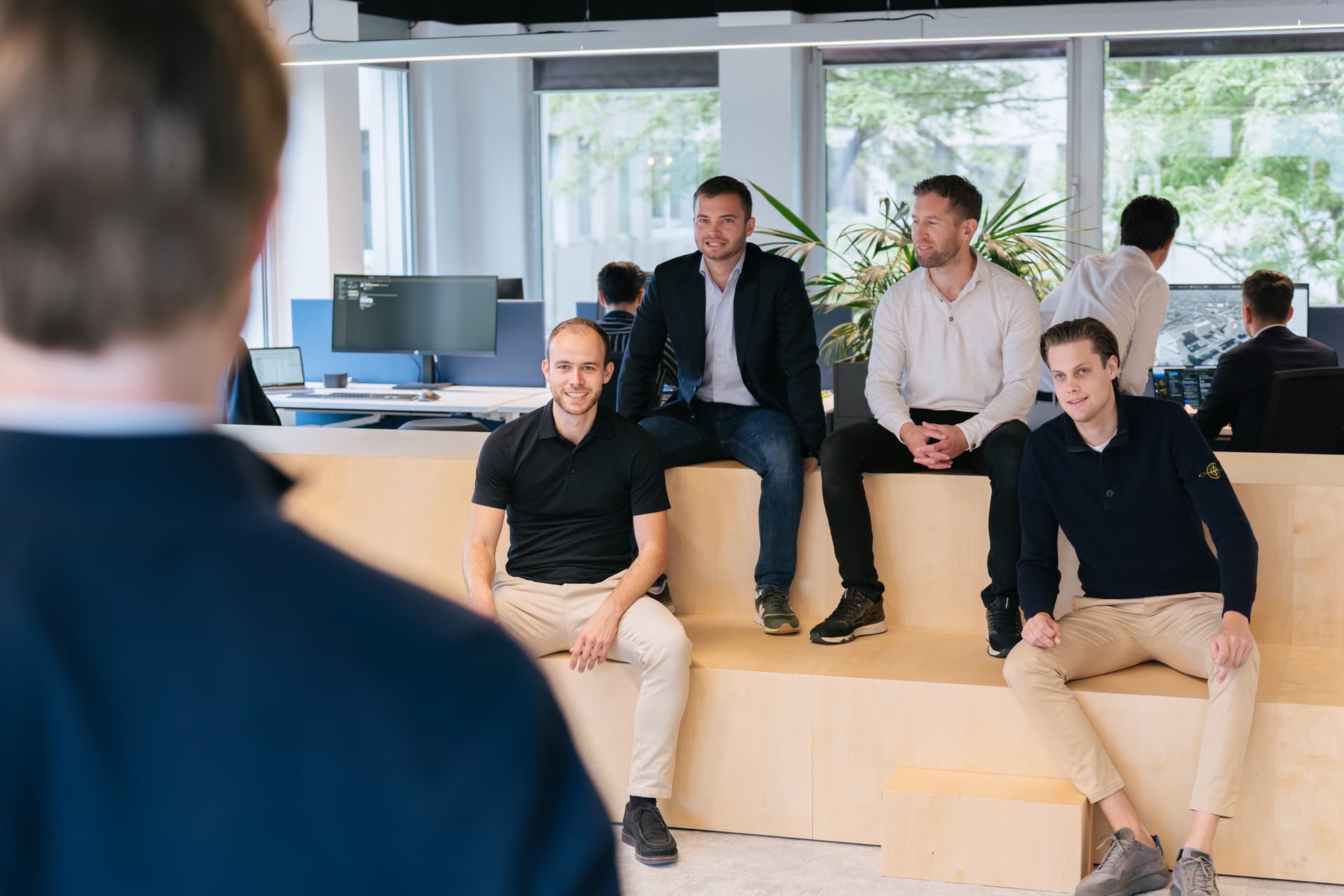 Vier mannen zittend op een meerlaags podium
