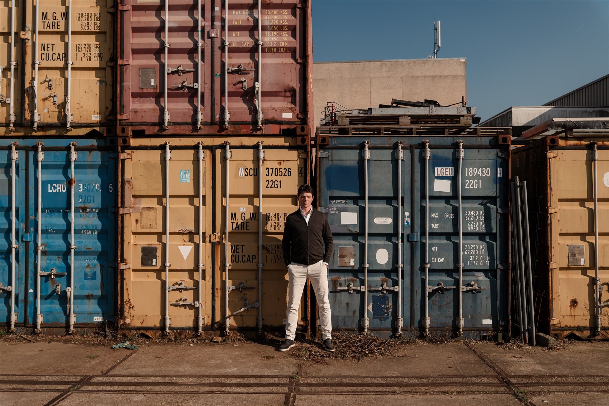 Man staat voor opgestapelde containers